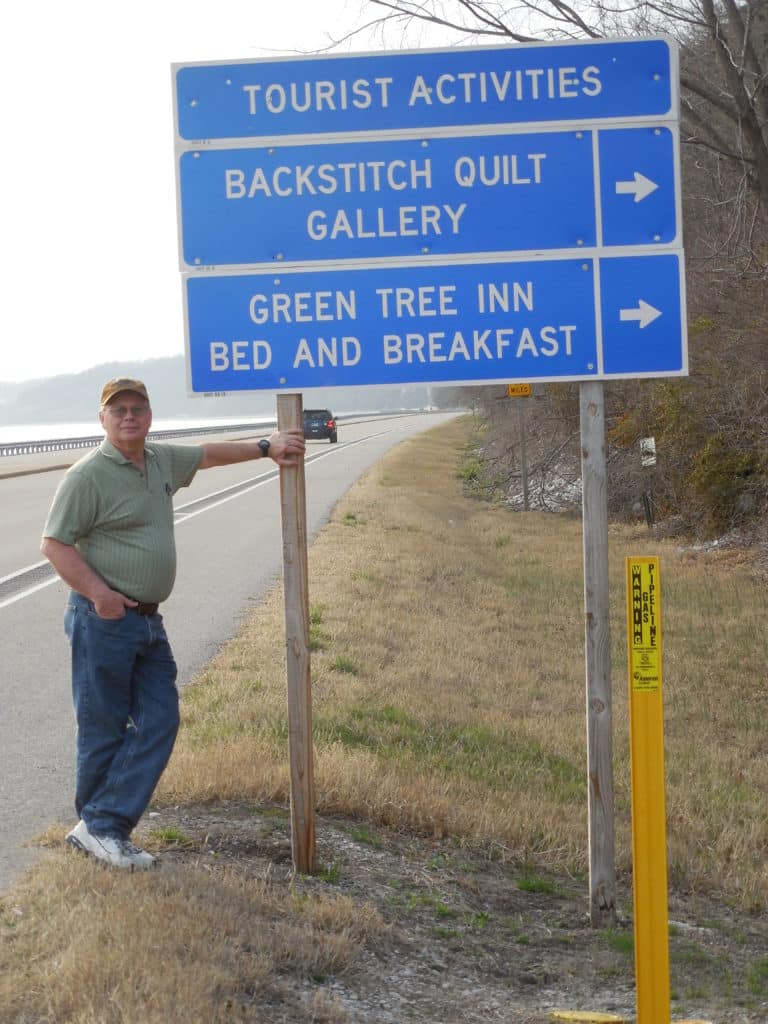 Gary standing beside IDOT transportation sign along the Great River Road