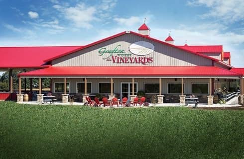 Exterior view of local winery painted light gray with red roof